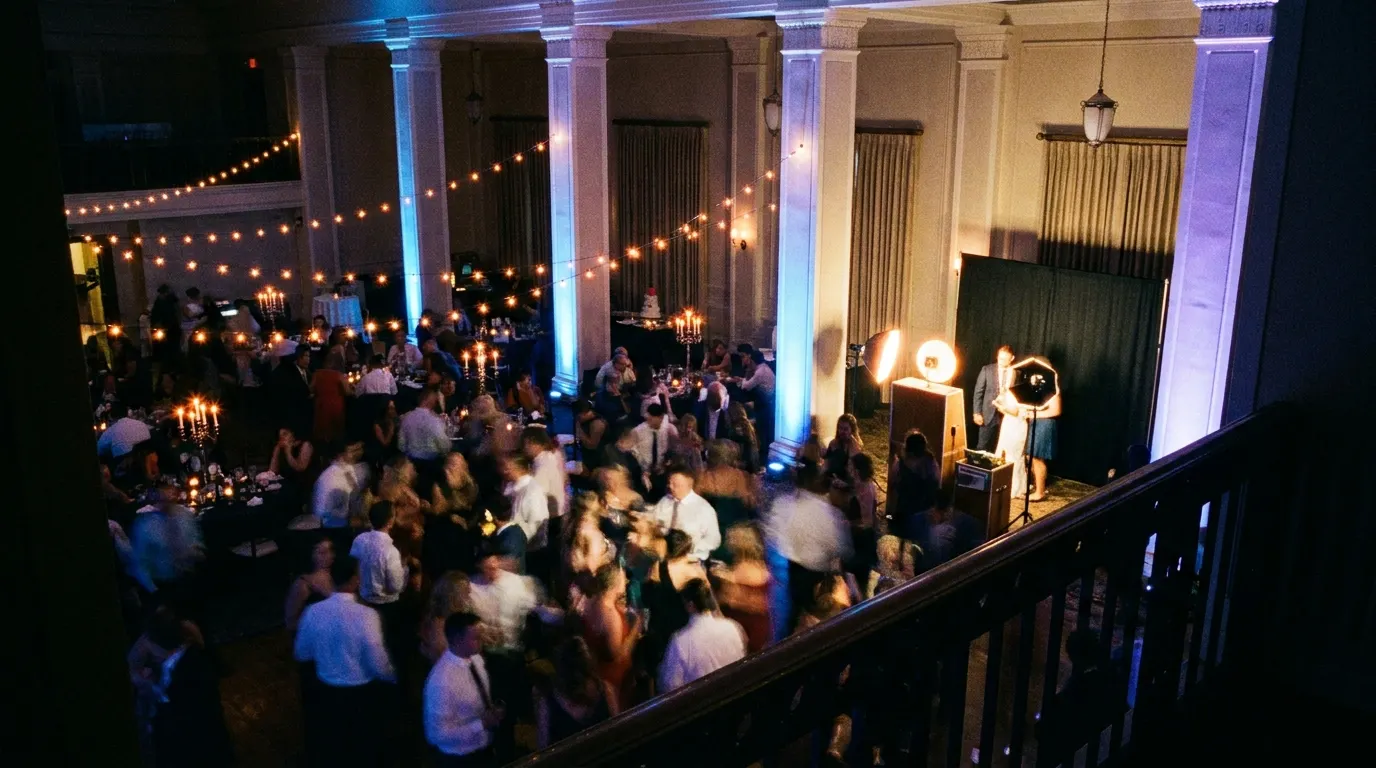 Elevated view of a packed dance floor with the lit Portrait Station in the corner