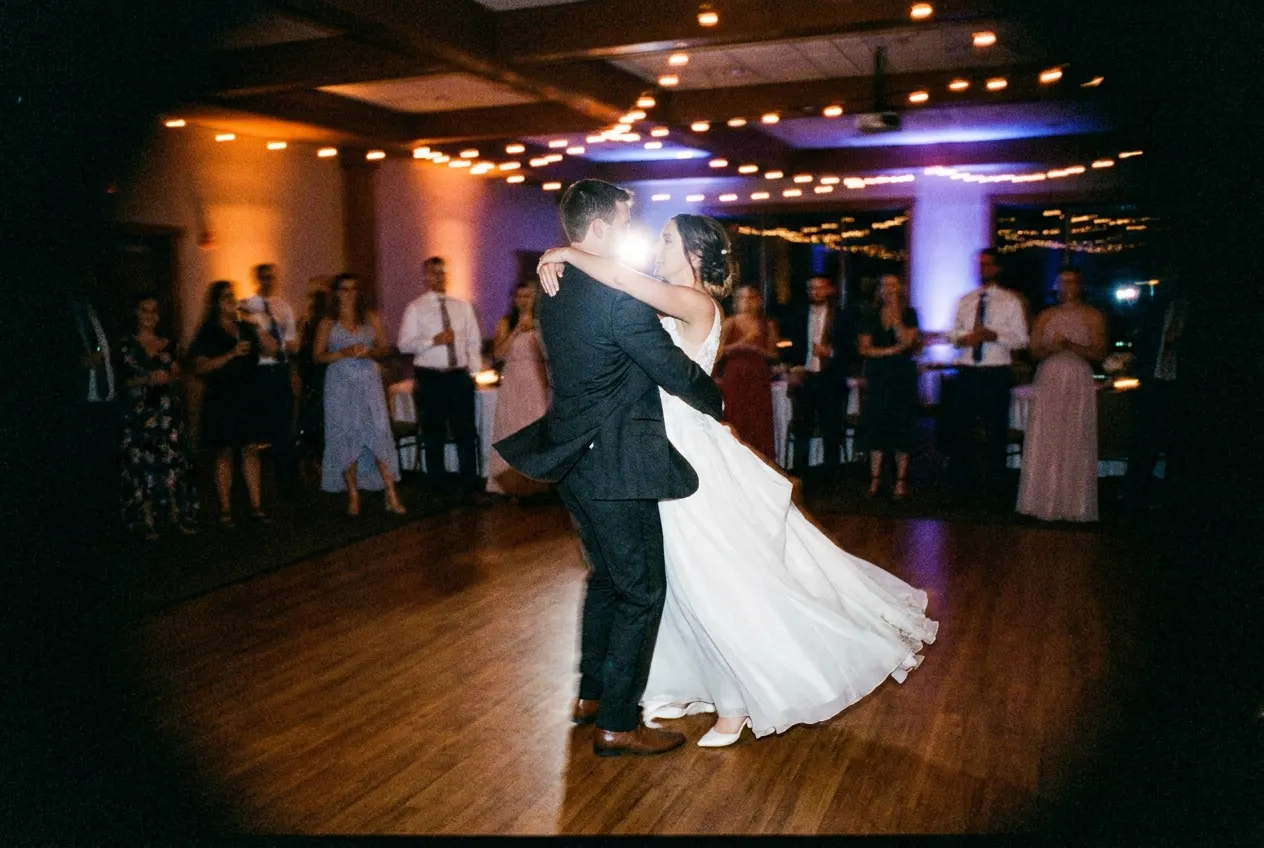 Flash-frozen couple mid first dance as the room blurs with motion around them